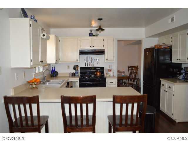 3233 Ransom Hills Road Richmond, VA 23237 - Photo 7 of 15 a kitchen with stainless steel appliances a stove a refrigerator a sink a stove and white cabinets