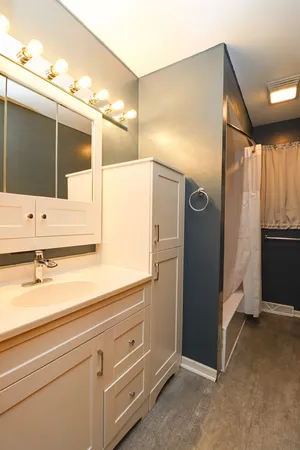 a bathroom with a tub sink and mirror