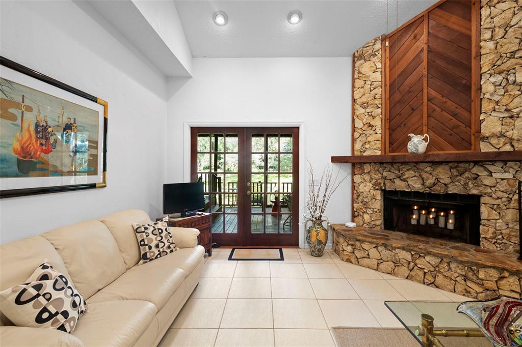 920 Shady Branch Trail DeLand, FL 32724 - Photo 16 of 46 a living room with furniture a fireplace and a large window