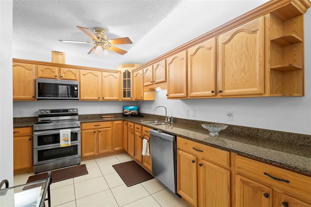 920 Shady Branch Trail DeLand, FL 32724 - Photo 20 of 46 a kitchen with stainless steel appliances granite countertop a stove a sink and a microwave