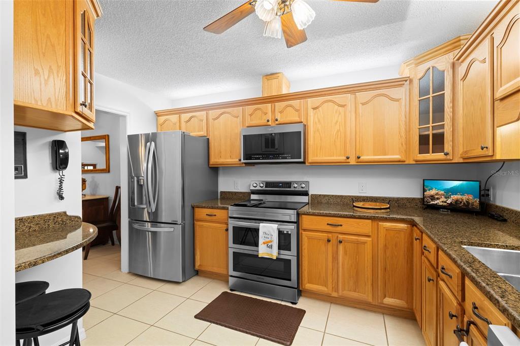 920 Shady Branch Trail DeLand, FL 32724 - Photo 21 of 46 a kitchen with stainless steel appliances granite countertop a stove a sink and a refrigerator