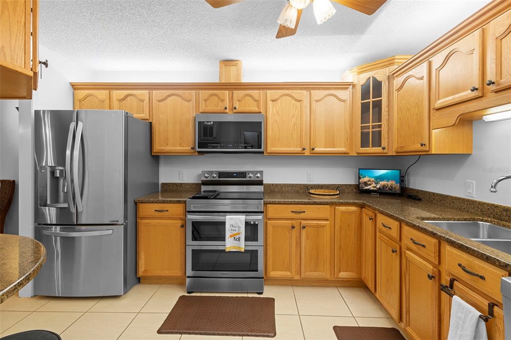 920 Shady Branch Trail DeLand, FL 32724 - Photo 22 of 46 a kitchen with stainless steel appliances granite countertop a refrigerator and a stove top oven