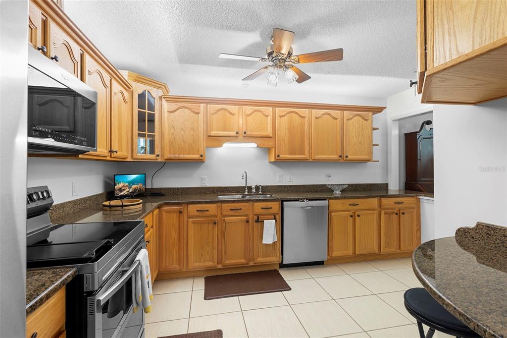 920 Shady Branch Trail DeLand, FL 32724 - Photo 23 of 46 a kitchen with stainless steel appliances granite countertop a sink stove and cabinets