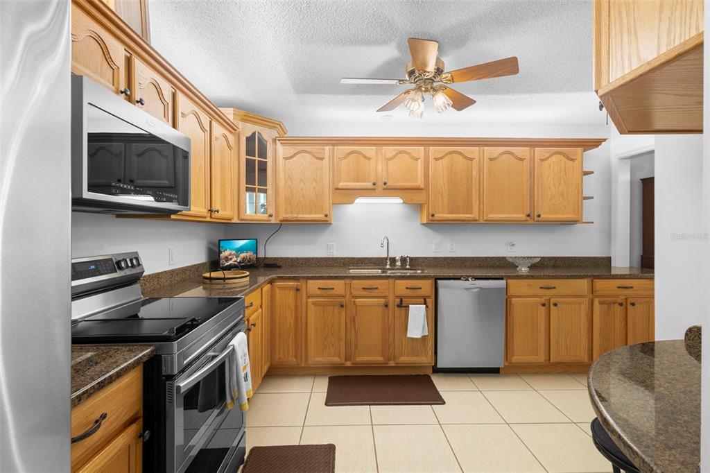 920 Shady Branch Trail DeLand, FL 32724 - Photo 24 of 46 a kitchen with stainless steel appliances granite countertop a sink stove and microwave