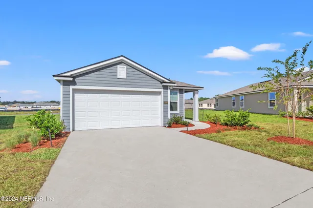 a front view of a house with yard and garage