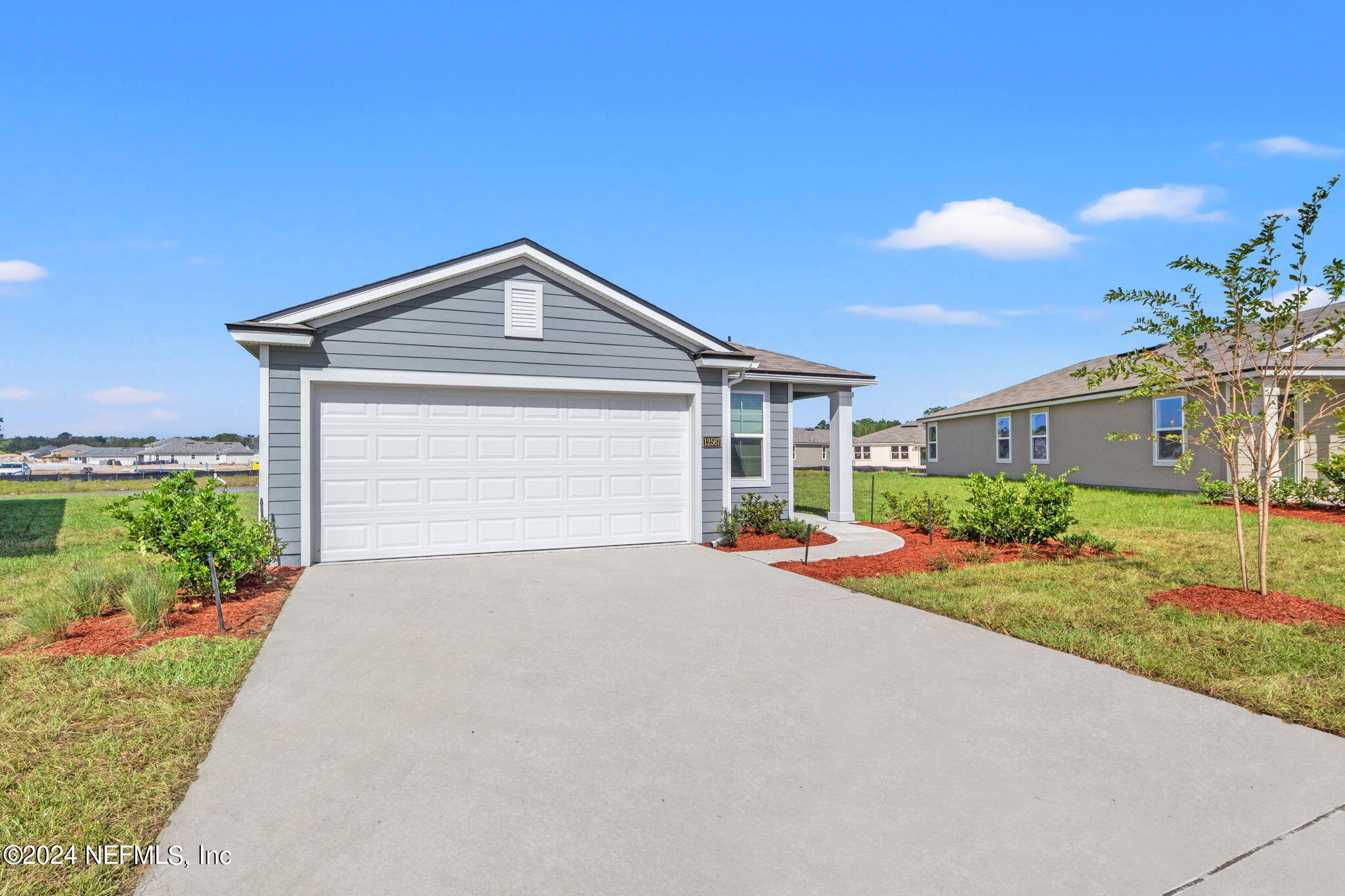 12567 Rubber Fig Terrace Jacksonville, FL 32218 - Photo 2 of 21 a front view of a house with yard and garage