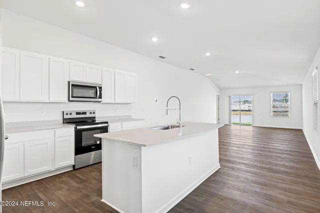 a kitchen with stainless steel appliances granite countertop a sink and stove top oven