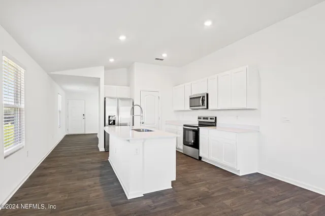 a kitchen with white cabinets and stainless steel appliances