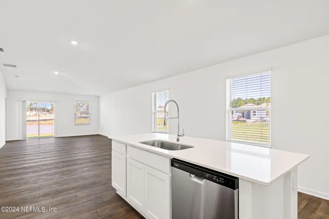 a kitchen with a sink cabinets and wooden floor