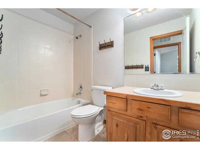 a bathroom with a granite countertop sink toilet a large mirror a bathtub and shower