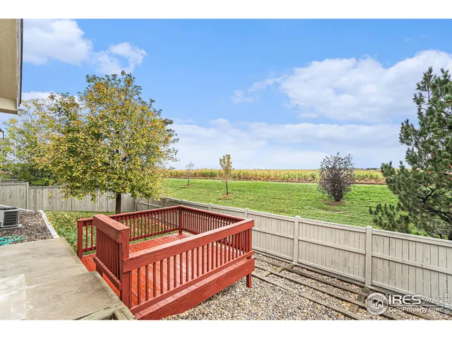 a view of a roof deck with couches and wooden fence