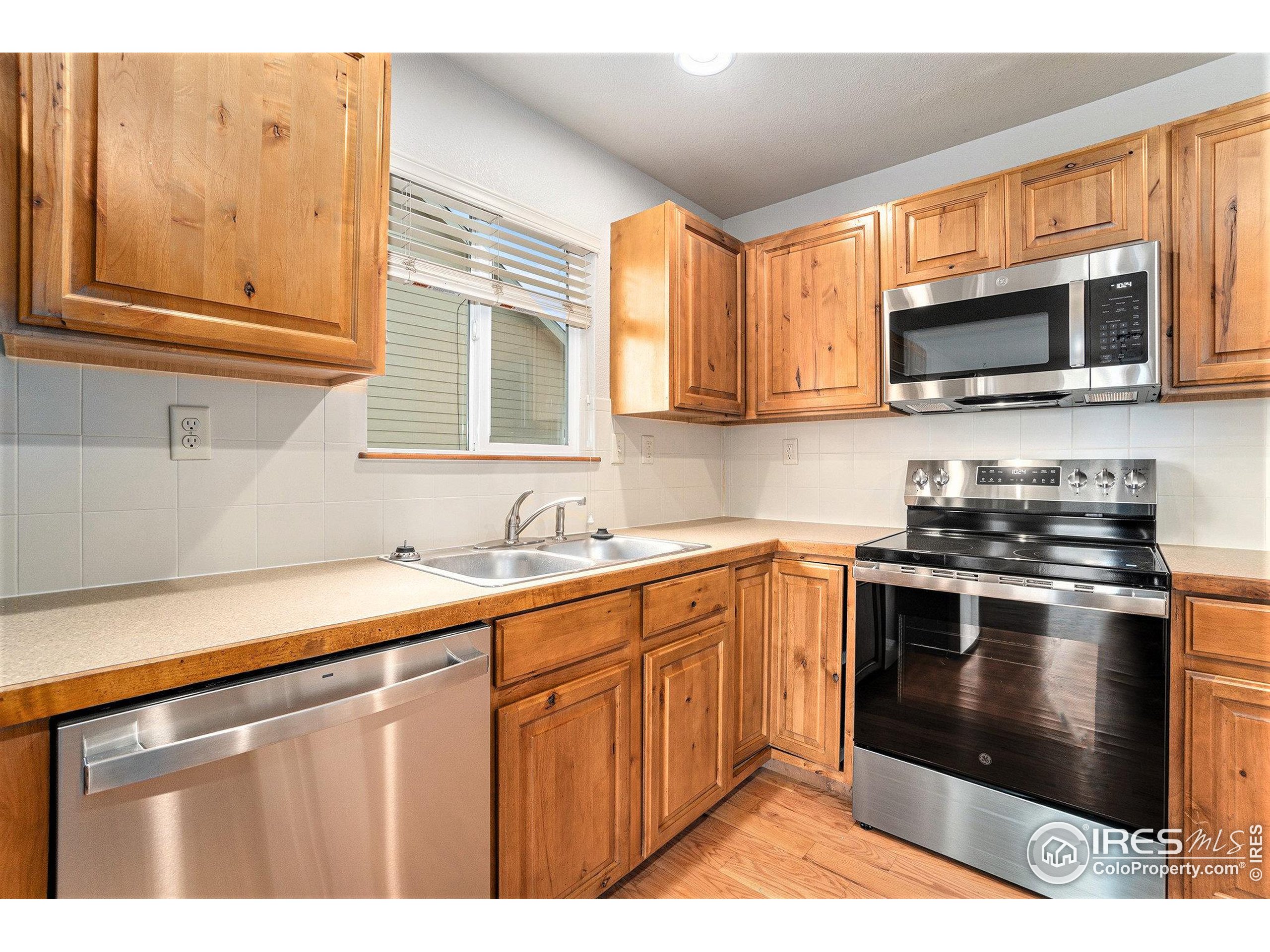 3474 Iron Horse Way Wellington, CO 80549 - Photo 8 of 20 a kitchen with stainless steel appliances granite countertop a stove a sink and a microwave