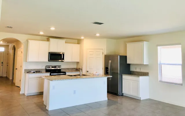 a kitchen with stainless steel appliances a refrigerator stove microwave and sink
