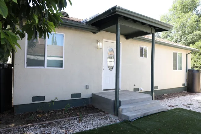 a backyard of a house with table and chairs