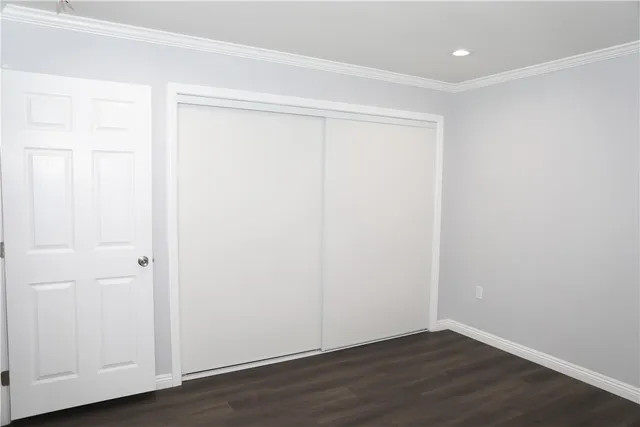 an empty room with wooden floor and closet