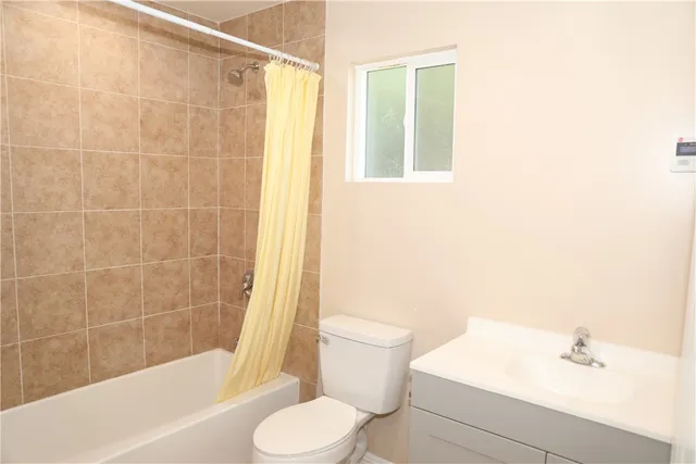 a white toilet sitting next to a bath tub