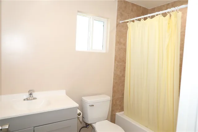 a bathroom with a sink a toilet and shower curtain