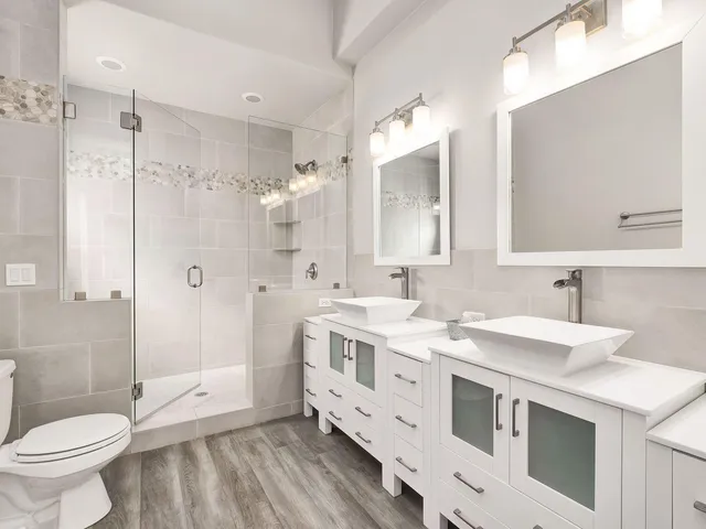 a bathroom with a double vanity sink toilet and shower
