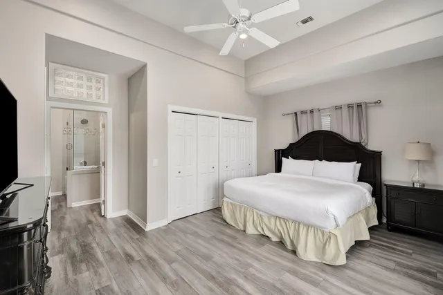 a bedroom with a bed and a flat tv screen on dresser