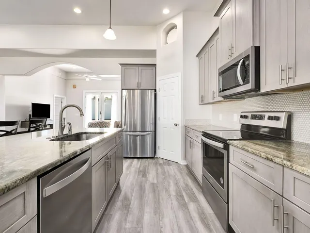 a kitchen with granite countertop stainless steel appliances and sink