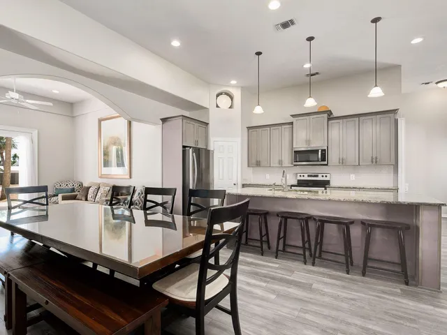 a kitchen with a dining table chairs sink and wooden floor
