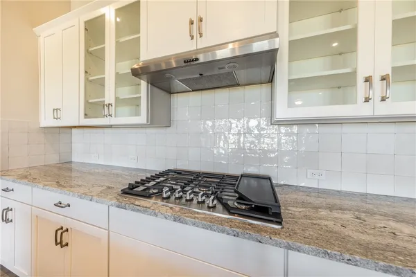 a kitchen with granite countertop a sink and a stove