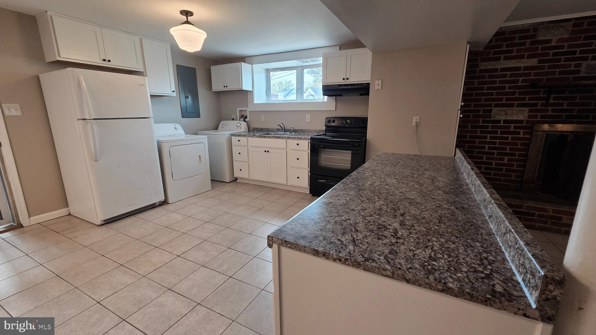 4400 4th Street Baltimore, MD 21225 - Photo 9 of 25 a kitchen with a sink a refrigerator and cabinets