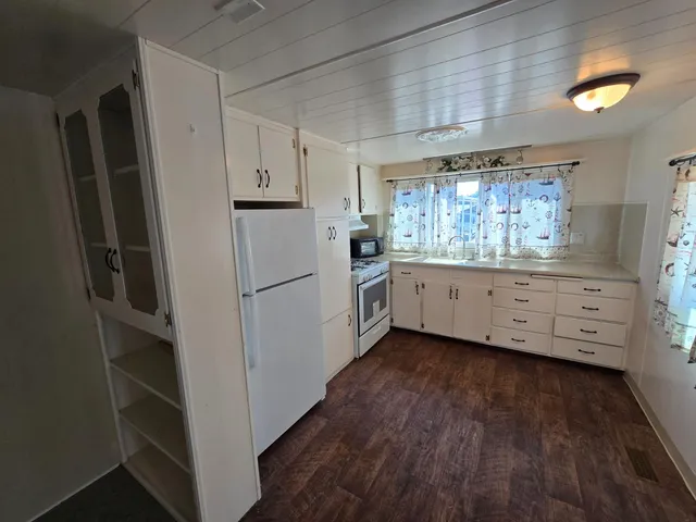a kitchen with granite countertop a refrigerator and a stove top oven