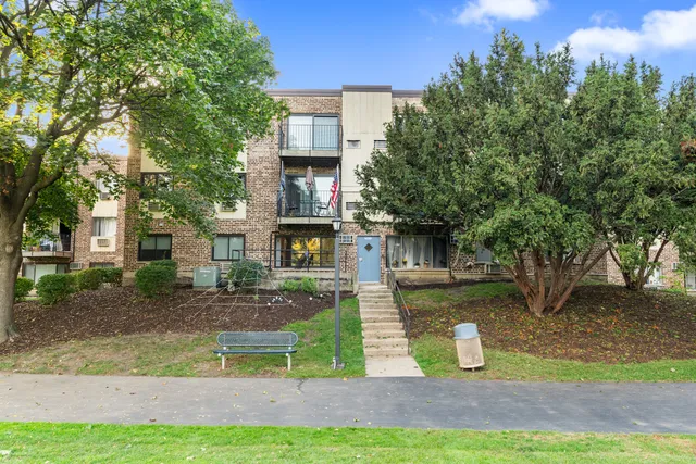a front view of a house with garden and sitting area