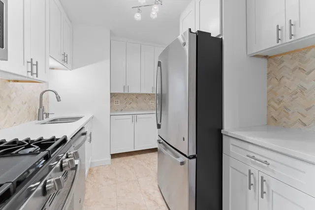 a kitchen with stainless steel appliances granite countertop a stove and a microwave
