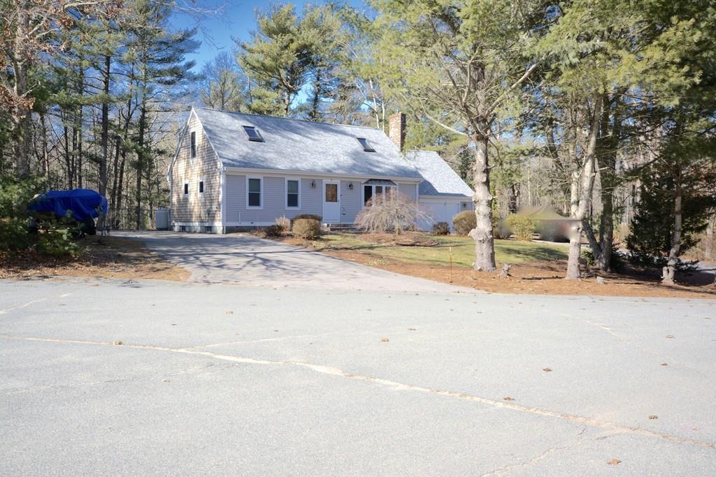 a view of a house with a yard and large tree