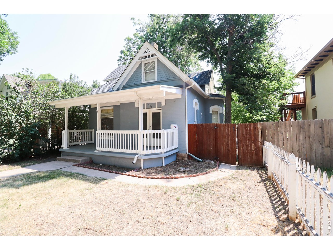 608 South Howes Street Fort Collins, CO 80521 - Photo 2 of 28 a view of a house with a small yard and wooden fence