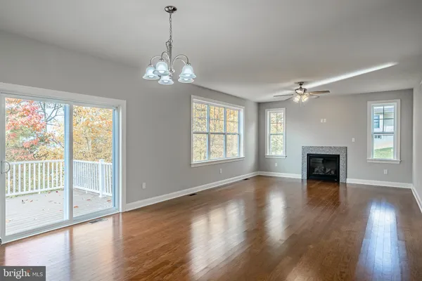 a view of a livingroom with wooden floor fireplace and windows