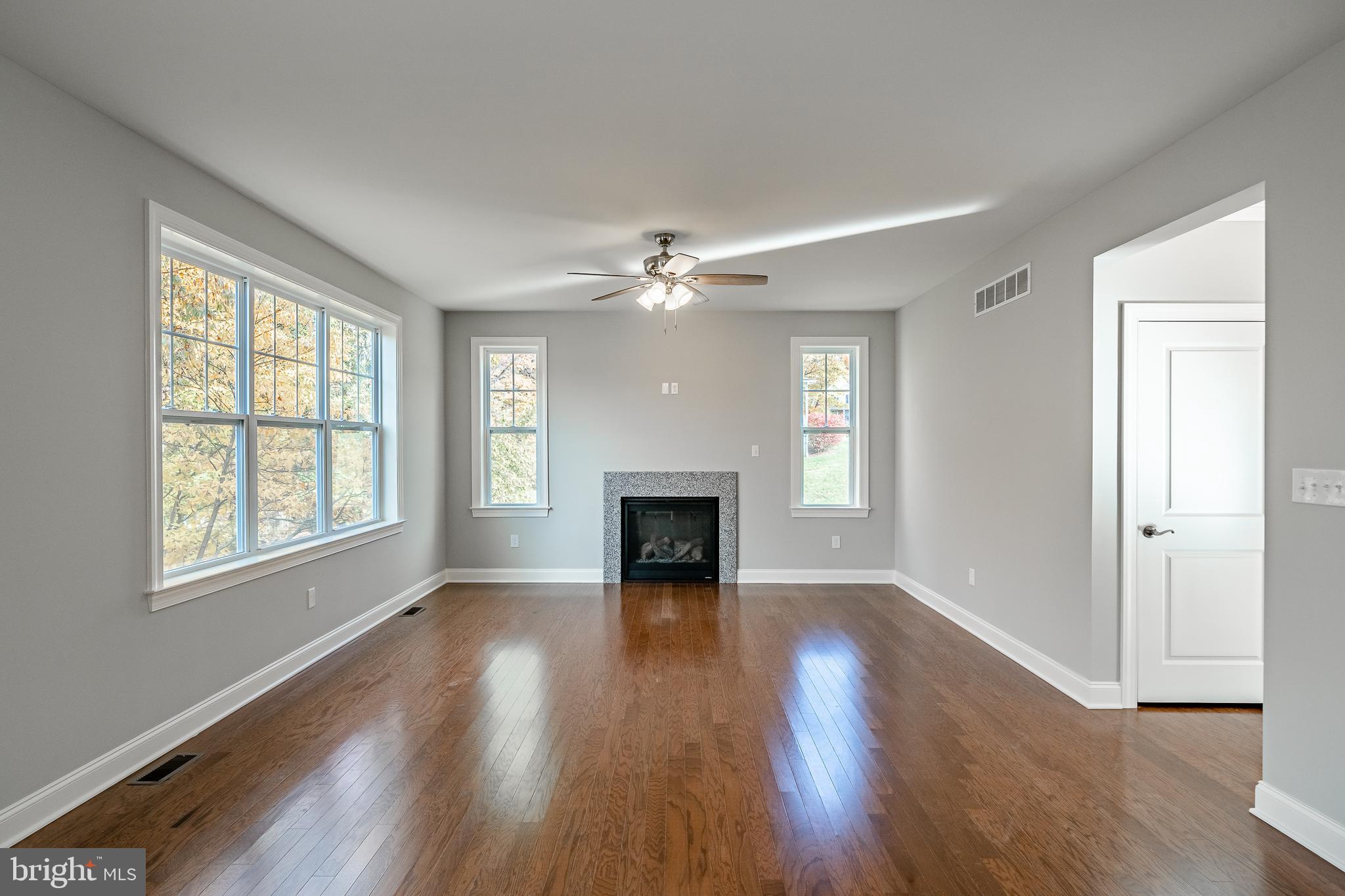 2158 Key Court Kutztown, PA 19530 - Photo 14 of 39 an empty room with wooden floor fireplace and windows