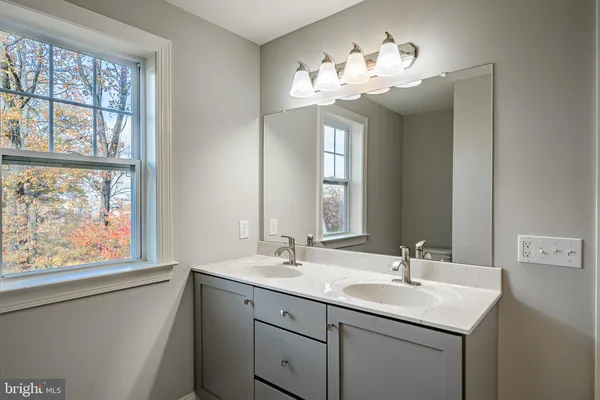 a bathroom with a toilet a sink and a mirror