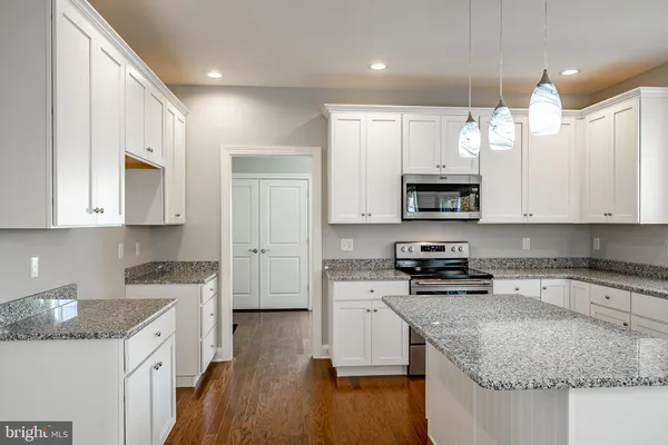 a kitchen with stainless steel appliances granite countertop a sink stove and microwave