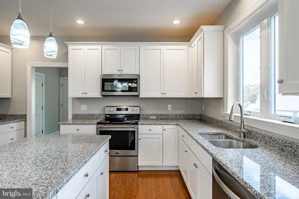 a kitchen with stainless steel appliances granite countertop a sink a stove and a granite counter tops