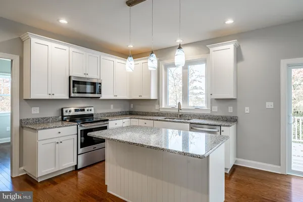 a kitchen with stainless steel appliances granite countertop a sink stove and microwave
