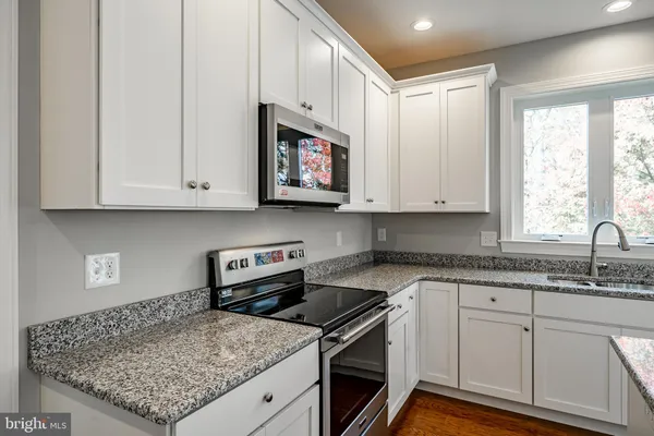 a kitchen with stainless steel appliances granite countertop a sink stove and cabinets