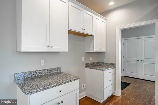 a kitchen with granite countertop white cabinets and a sink