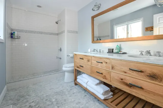 a bathroom with a granite countertop toilet sink and a mirror
