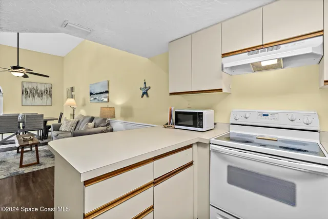 a kitchen with a stove cabinets and wooden floor
