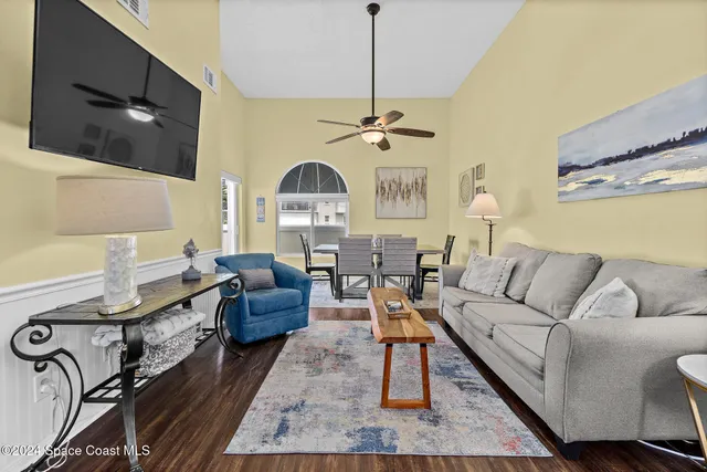 a living room with furniture a rug and a flat screen tv