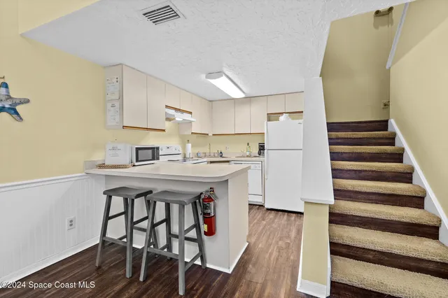 a kitchen with a table chairs refrigerator and cabinets