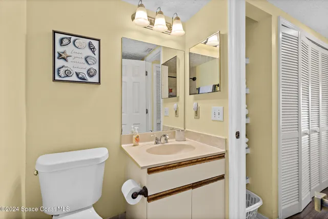 a bathroom with a sink mirror vanity and toilet
