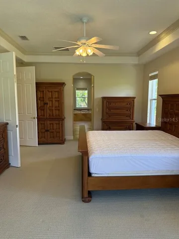 a bedroom with a large bed and a chandelier