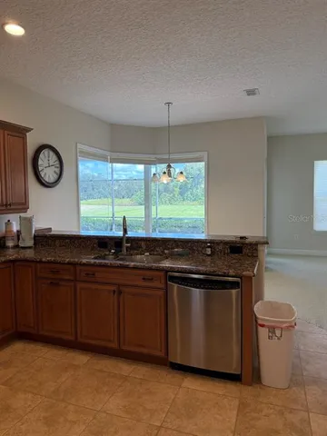 a kitchen with stainless steel appliances granite countertop a refrigerator a sink a stove a microwave and island