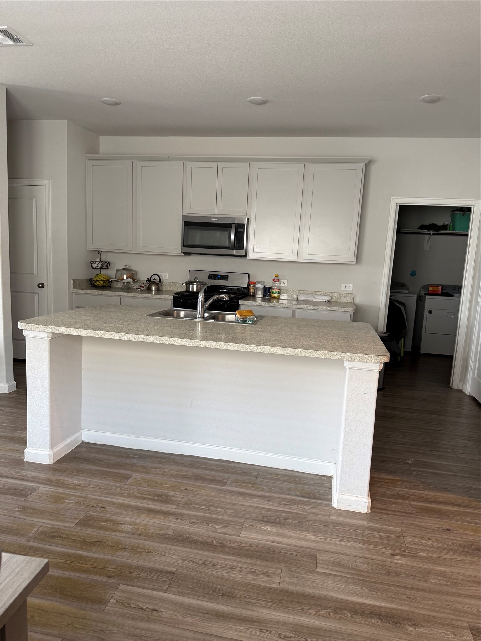 20931 Endeavor Street Porter, TX 77365 - Photo 4 of 15 a white kitchen with a sink a stove a microwave and cabinets