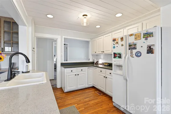 a kitchen with stainless steel appliances a refrigerator sink and white cabinets