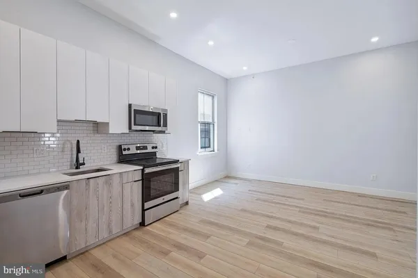 a kitchen with granite countertop white cabinets and stainless steel appliances